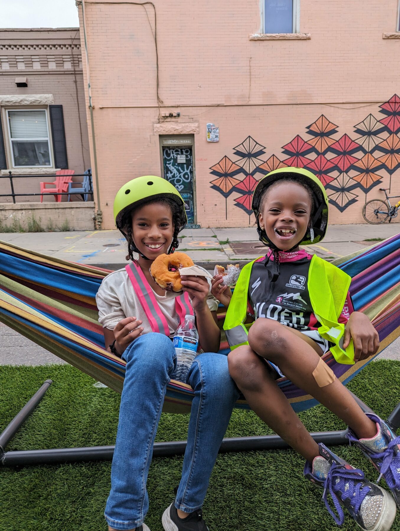 Two young cyclists smiling in a hammock